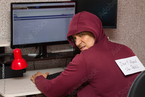 Fotografía Internet troll with the evil face sitting at the computer