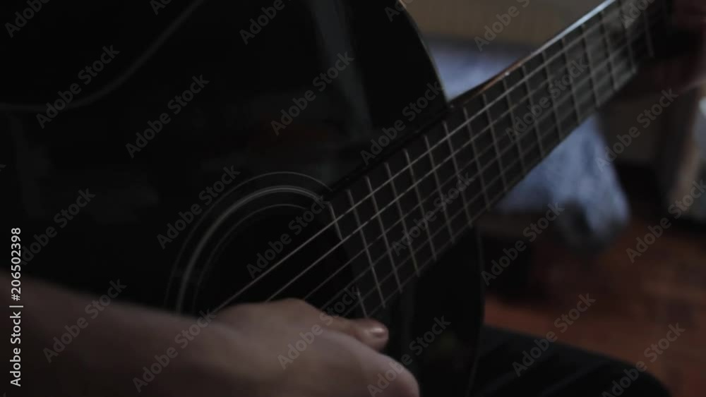 Detalle de un joven tocando la guitarra