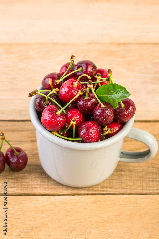 cherries in a white enamel mug on a wooden table, fresh cherry, seasonal berries, sweet cherry, ripe berries, berries in a mug cherries in a white enamel mug on a wooden table, fresh cherry, seasonal berries, sweet cherry, ripe berries, berries in a mug