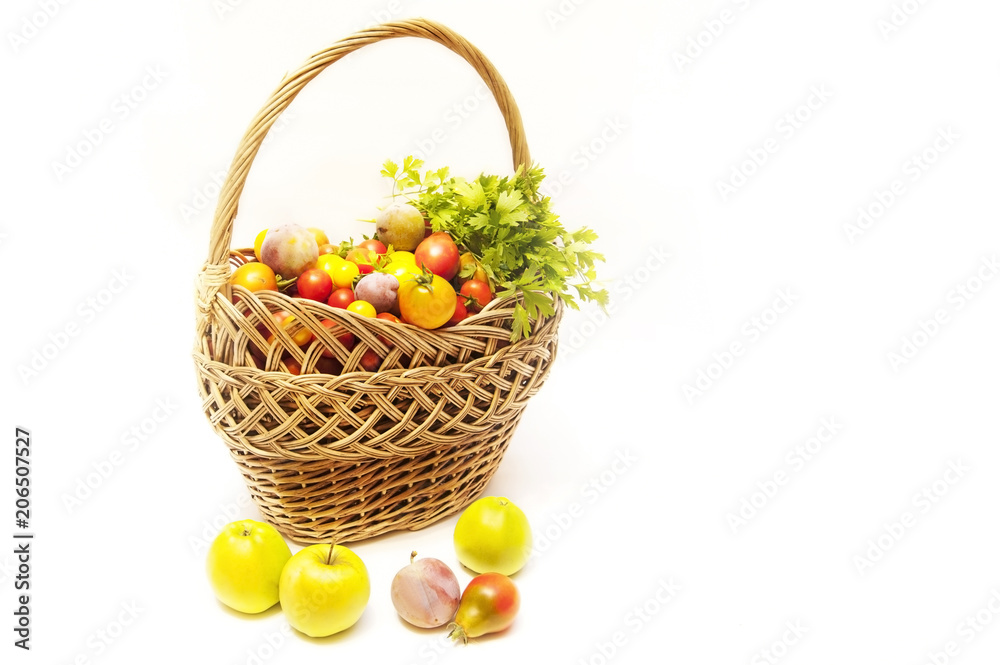 Summer harvest is in a wooden basket - vegetables and fruits on white background