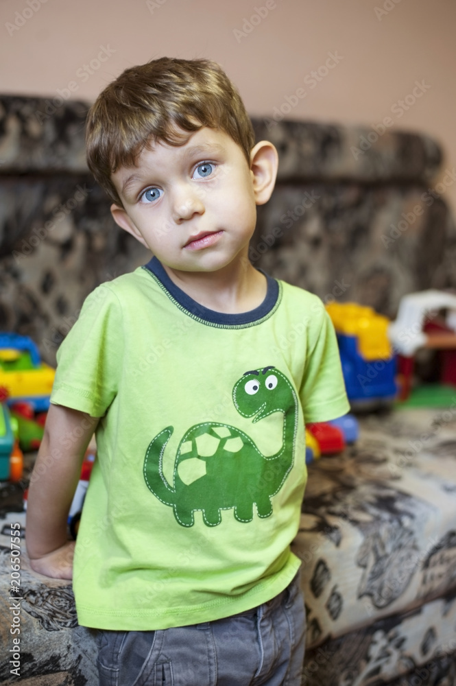 A little boy with beautiful blue eyes plays in a children's room with toys A little boy with beautiful blue eyes plays in a children's room with toys