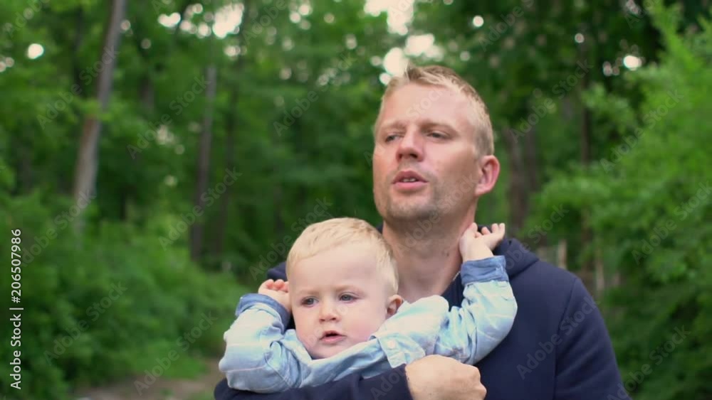 Happy family Little boy on fathers hands walking in park