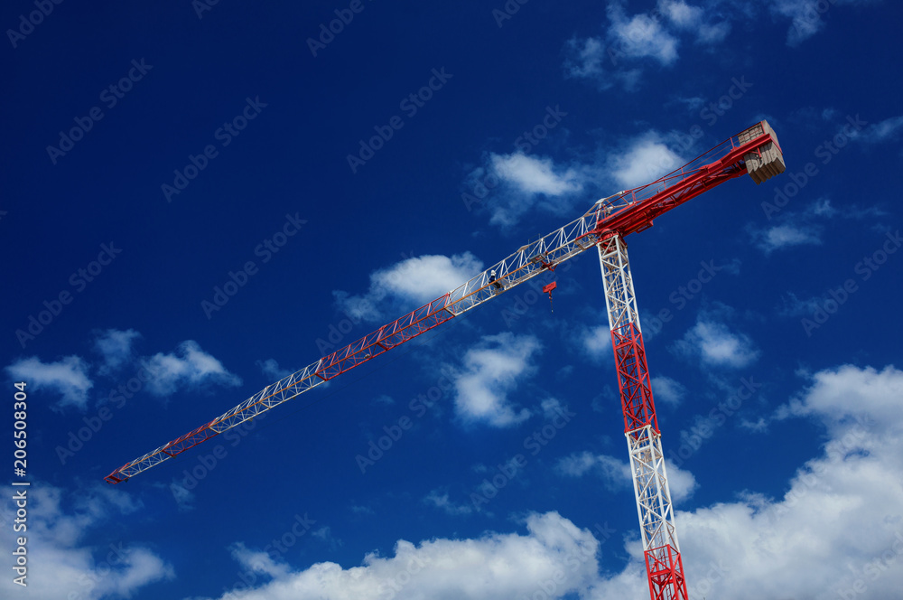 Red and white construction crane with blue sky and clouds Red and white construction crane with blue sky and clouds