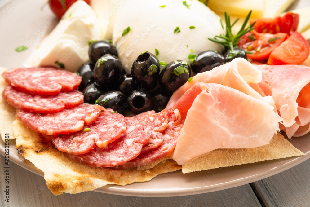 Piatto con salame, prosciutto, mozzarella di bufala campana e olive nere Piatto con salame, prosciutto, mozzarella di bufala campana e olive nere
