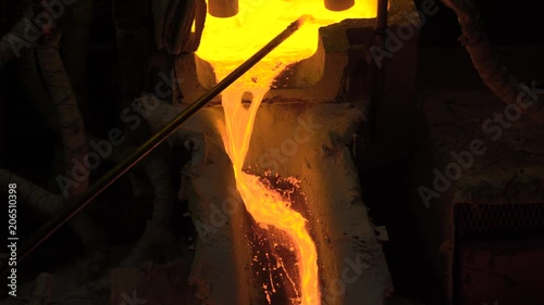 Hot steel pouring at steel plant. In the frame, molten metal is poured through special channels, for the further rolling with a special machine. Modern metallurgical industry photo