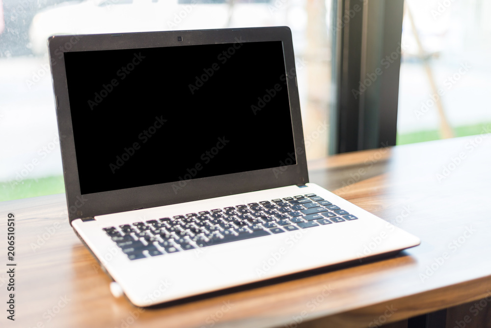 Mockup image of laptop with blank white screen on wooden table of In the coffee shop. Mockup image of laptop with blank white screen on wooden table of In the coffee shop.