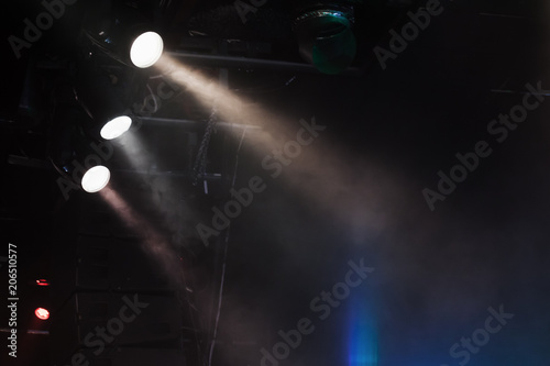 Three spot lights with strong beams in smoke