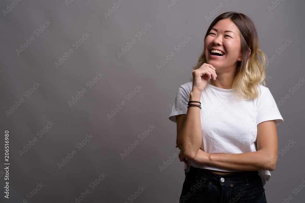 Young beautiful Kazakh woman against gray background