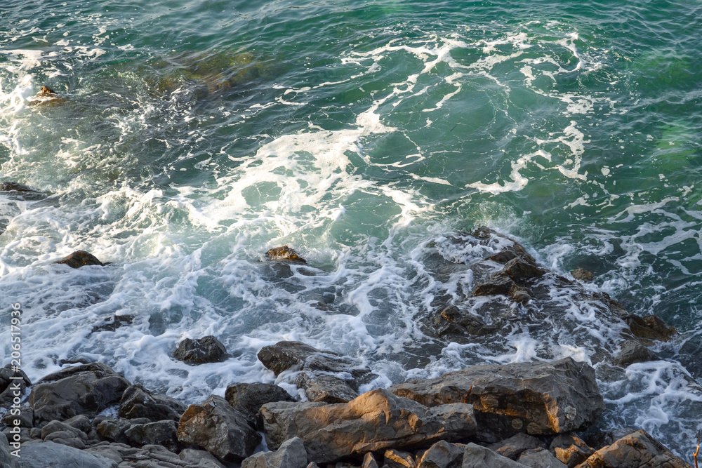Huge stones in the sea and waves. Sea foam On a sunny day. View from above. Montenegro. The Budva Riviera Huge stones in the sea and waves. Sea foam On a sunny day. View from above. Montenegro. The Budva Riviera