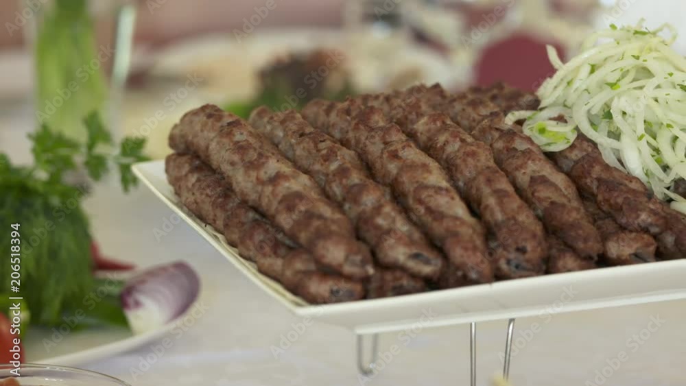 Armenian lula kebab served on decorative platter with chopped onion. Grilled kebabs is a popular dish of Middle Eastern cuisine Armenian lula kebab served on decorative platter with chopped onion. Grilled kebabs is a popular dish of Middle Eastern cuisine