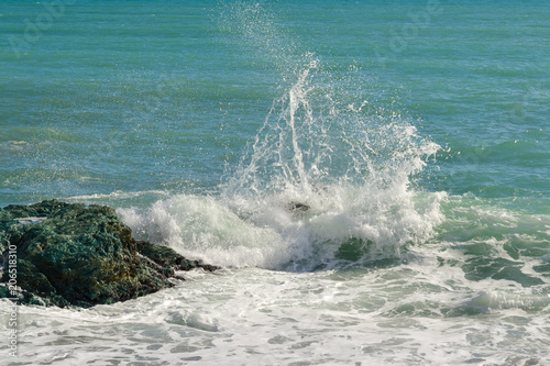 Big waves breaking on the shore with sea foam