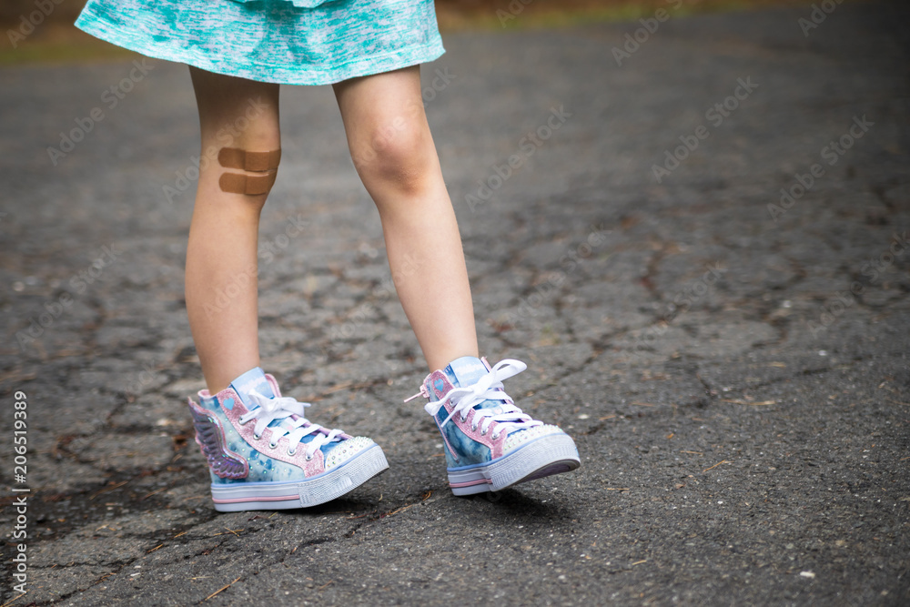 little girl with bandaid on knees