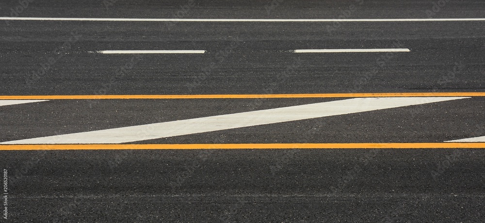 Yellow and white paint line on black asphalt. space transportation background