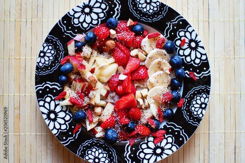 Colorful vegan oatmeal breakfast with fruit and nuts photo