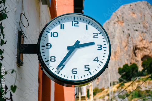 classic clock hanging on the wall at the railway station photo