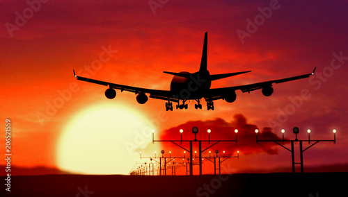 Airplane silhouette landing on sunset photo