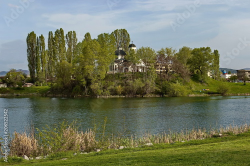 Early springtime green, lake, bell tower and church with modern architecture in district Drujba, Sofia, Bulgaria 