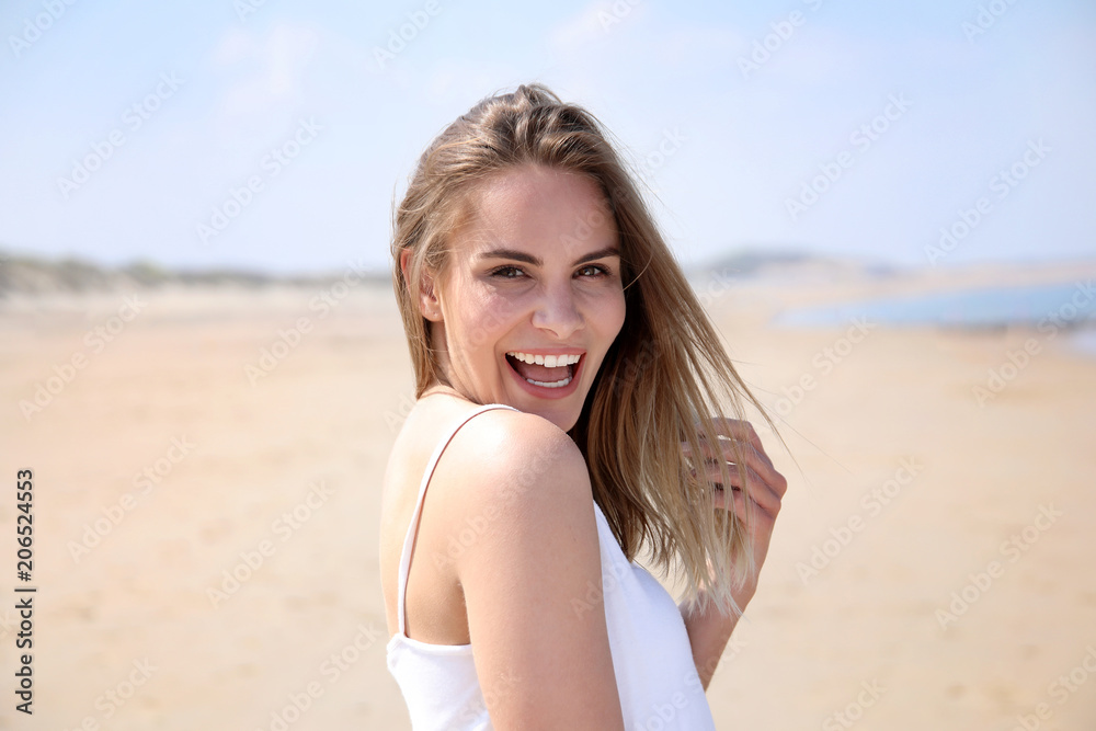 Hübsche blonde Frau an einem Strand lacht Hübsche blonde Frau an einem Strand lacht