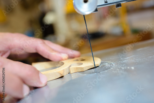 Fotografie Closeup of blade cutting out guitar bridge