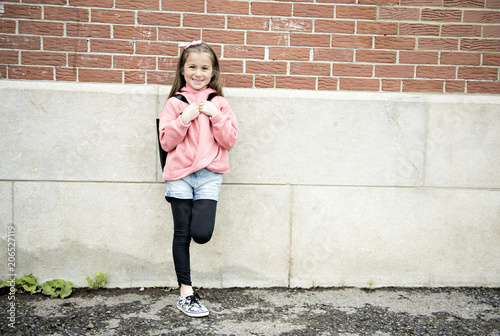 Portrait of cute girl with backpack outside of school © Louis-Photo