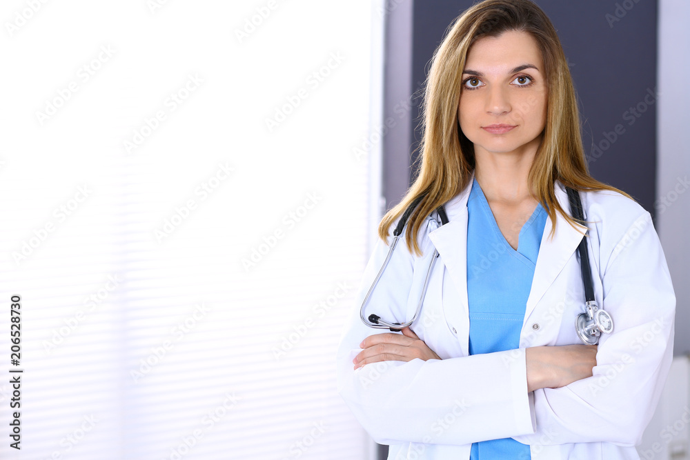 Woman doctor at work in hospital office. Portrait of female physician with arms crossed. Medicine and health care concept Woman doctor at work in hospital office. Portrait of female physician with arms crossed. Medicine and health care concept