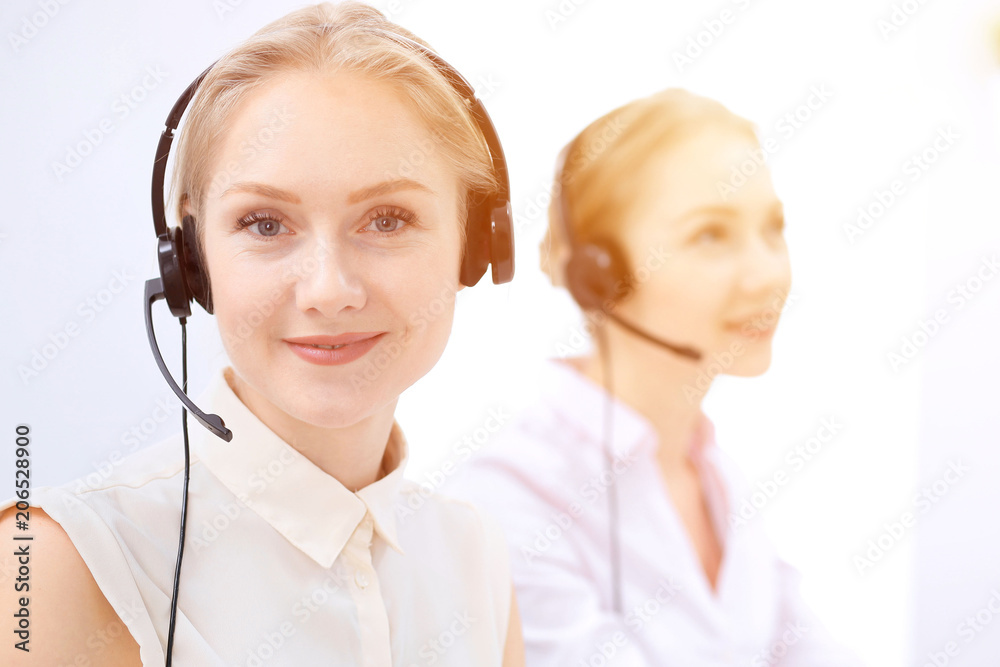 Bright call center office. Two blonde women in a headset Bright call center office. Two blonde women in a headset