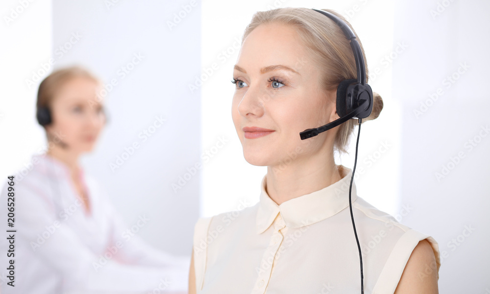 Bright call center office. Two blonde women in a headset Bright call center office. Two blonde women in a headset