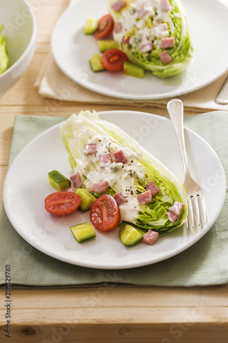 Classic wedge salad with tomatoes, cucumber, bacon and blue cheese dressing 