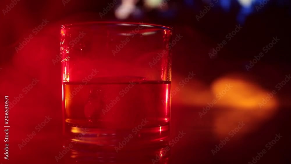 Selective focus pure whisky with ice cube inside whisky glass on dark foggy background alcohol drink concept. Close up. Slider shot Selective focus pure whisky with ice cube inside whisky glass on dark foggy background alcohol drink concept. Close up. Slider shot