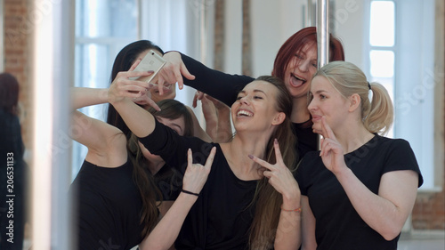Group of beautiful young women taking a selfie after a pole dance class