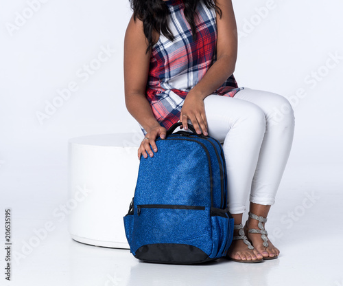 Young Stylish Girl Seated with a Blue Backpack