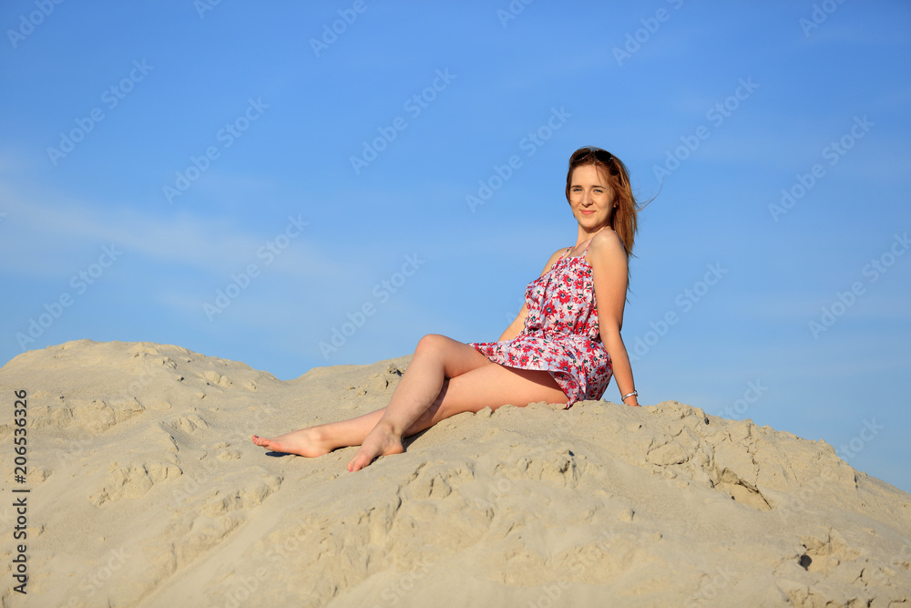 Piękna kobieta w letniej sukience na szczycie piaszczystej wydmy. - obrazy, fototapety, plakaty 