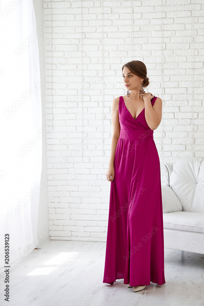 Portrait of a young beautiful woman in a burgundy long dress Portrait of a young beautiful woman in a burgundy long dress