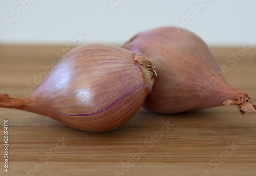 Pair of Shallots on a brown wooden table top