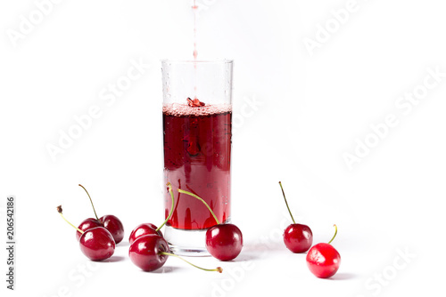 In a glass pour red juice, with berries, on a white background.