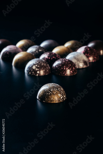 closeup view of pile of chocolate candies on black background