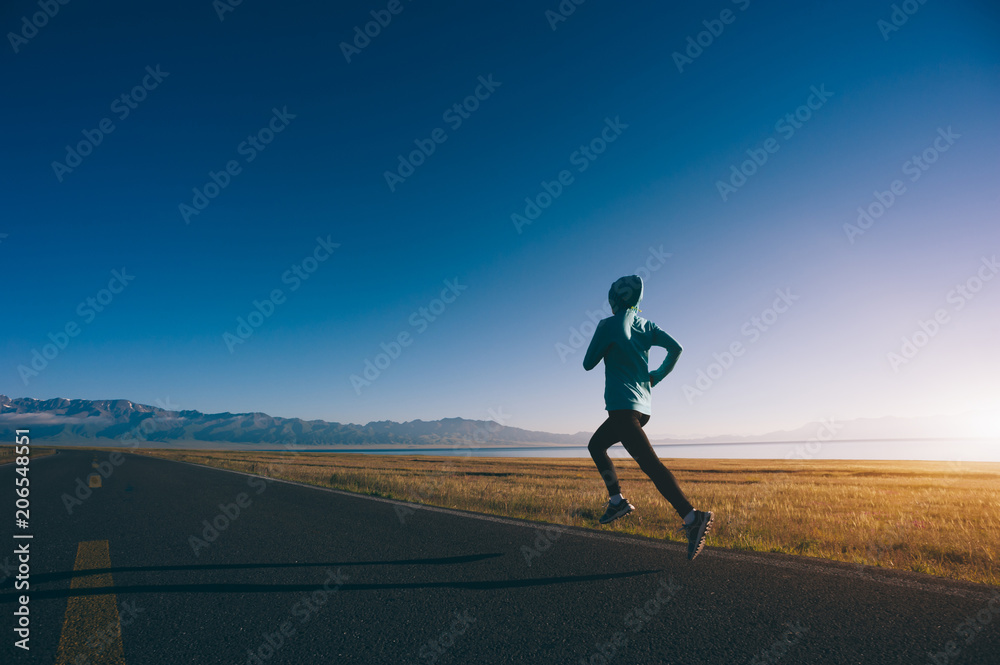 Obraz premium Young fitness sporty woman running on country road