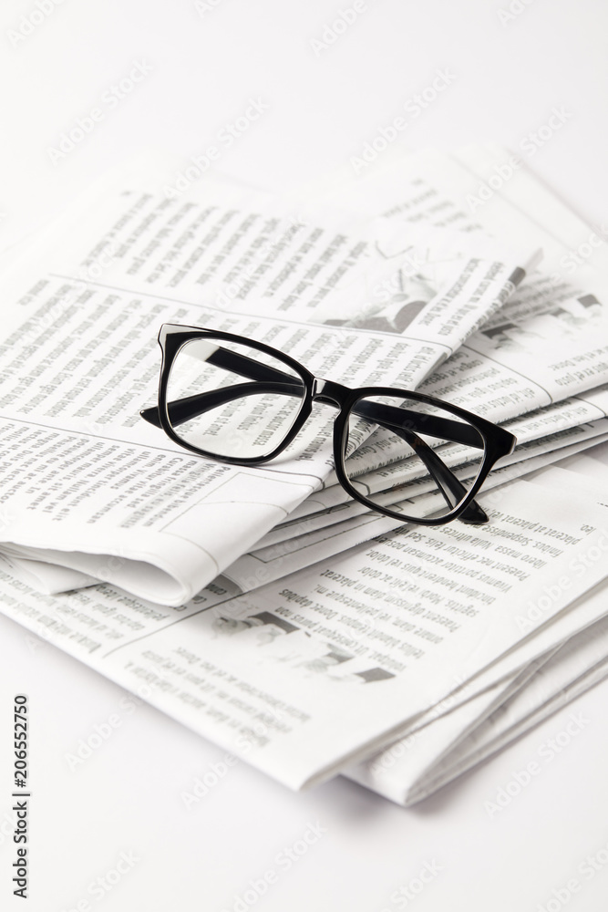close up of pile of newspapers and eyesight, on white close up of pile of newspapers and eyesight, on white