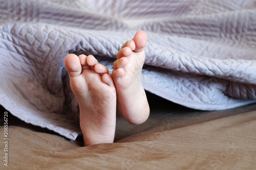 child's feet sticking out from under the blanket