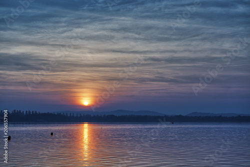 Beautiful sunset over the lake with cloudy sky © Massimo De Candido