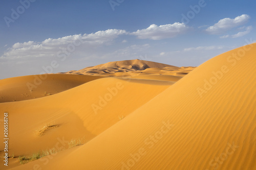 dunes and clouds above sand in Sahara desert in Morocco