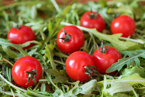 fresh, red cherry tomatoes on green arugula background