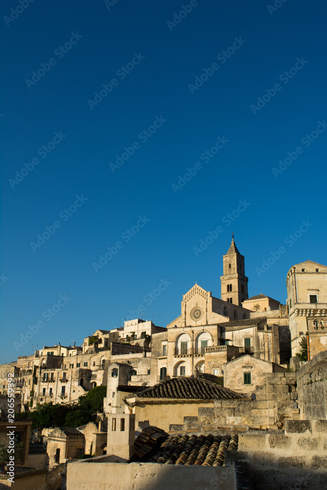 Vertical View of the City of Matera at Sunset on Clear Blue Sky Background
