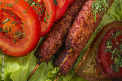 lulia kebab on a salad with tomatoes and dill photo