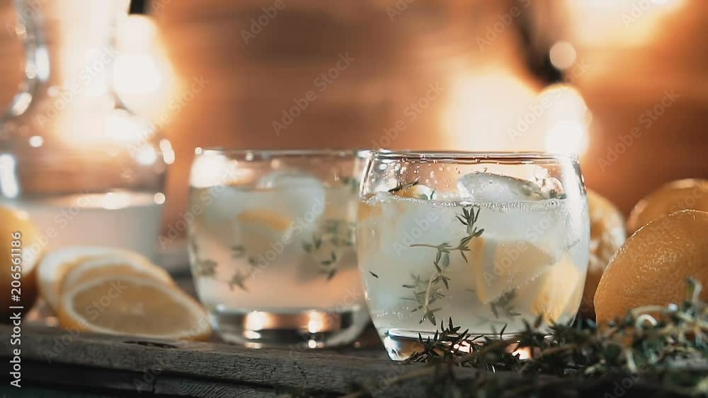 Ice cubes fall into drinking glass with cocktai Ice cubes fall into drinking glass with cocktai