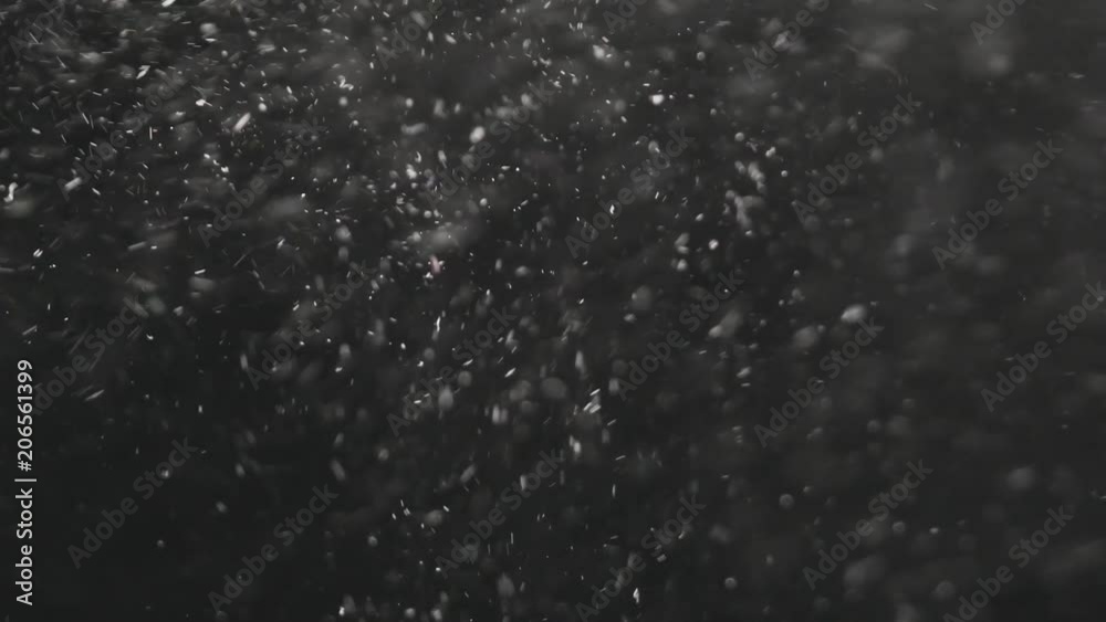 Slow motion dust particles explosive wave over black background Slow motion dust particles explosive wave over black background