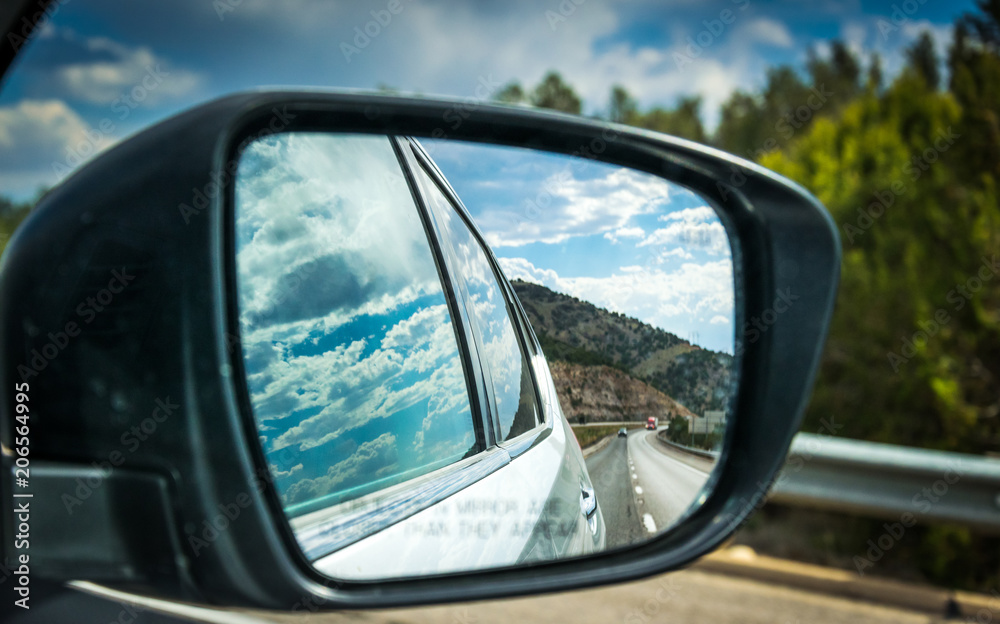 View of the highway in the side mirror of the car. Summer Car Tour in the USA