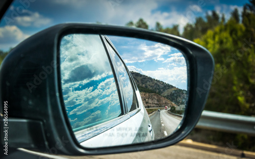 View of the highway in the side mirror of the car. Summer Car Tour in the USA