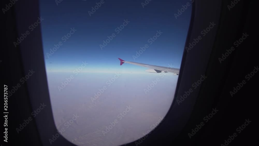 Mountain range from the airplane window. Airplane wing. Aerial view on mountains through window of an aircraft. Mountain from the airplane window. Travel concept. Mountain range from the airplane window. Airplane wing. Aerial view on mountains through window of an aircraft. Mountain from the airplane window. Travel concept.