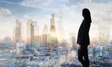 Young woman in suit looking over the City of London at sunrise 